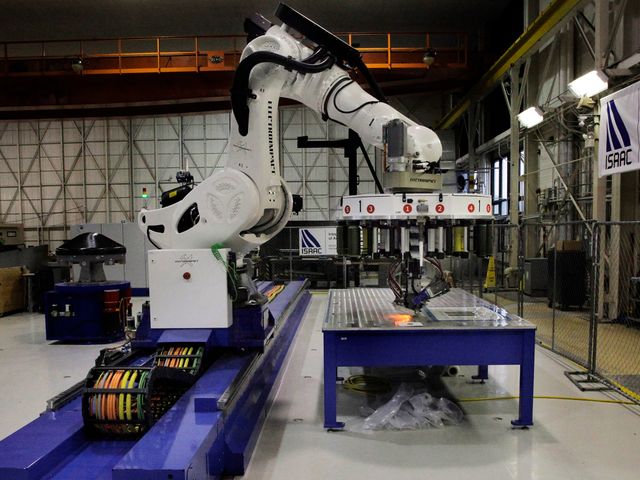 炭素繊維と樹脂の材料を配置するNASAの研究用ロボットISAAC