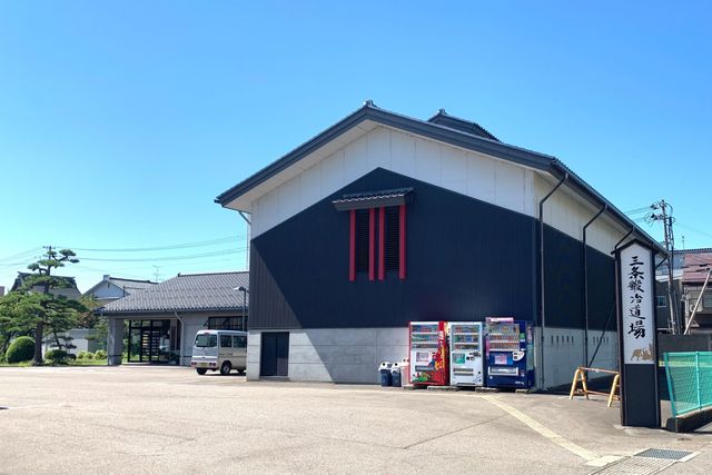 黒い外壁と三条鍛冶道場の看板が見える建物の外観