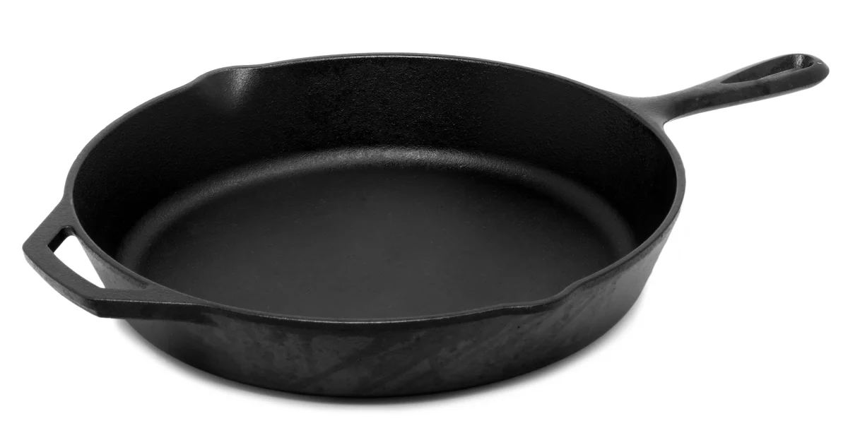 白い背景に置かれた、長い持ち手と補助の持ち手がある黒い鋳鉄製フライパン