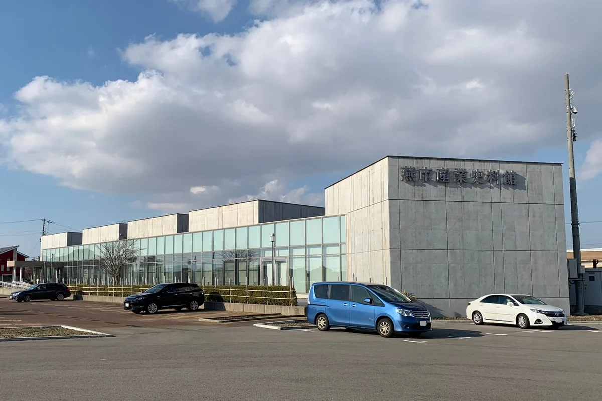 ガラス張りの壁と燕市産業史料館の館名が見える建物の外観